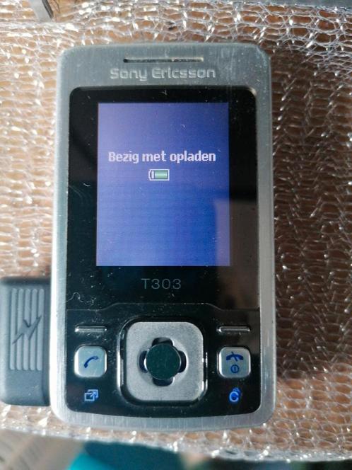 Kleine Sony Ericsson mobiel met oplader en hoesje.