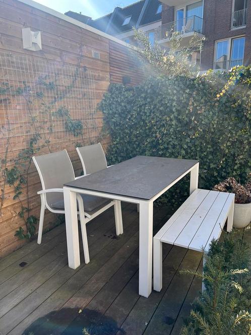 Mooie witte tuin tafel met twee stoelen en een bankje .