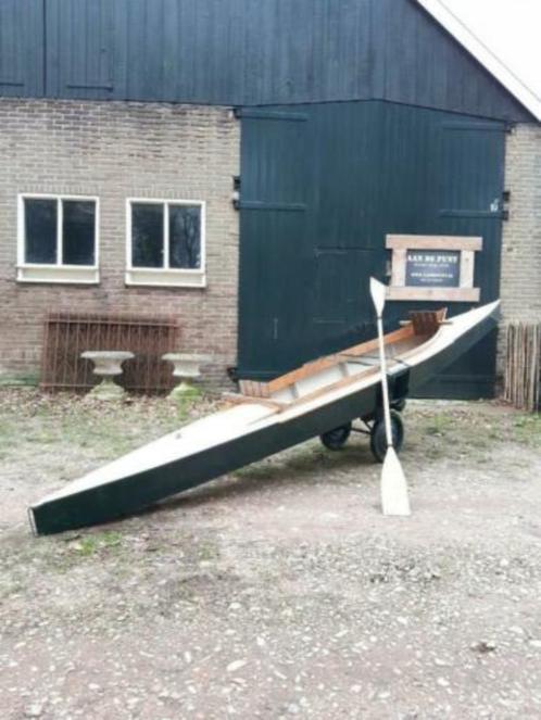 Oude vintage houten kano boot op karretje peddel