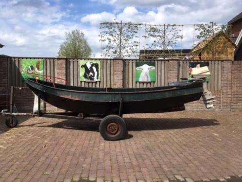 stalen roeiboot met trailer en buiten boordmotor