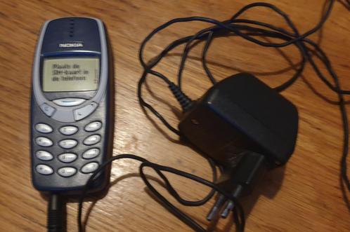 Vintage Nokia telefoon met oplader.