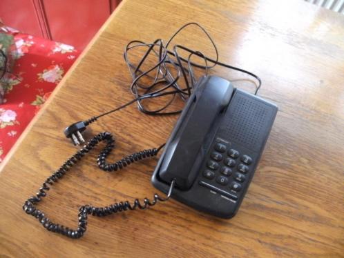Zwarte vaste telefoon met bijbehorende kabeltjes.